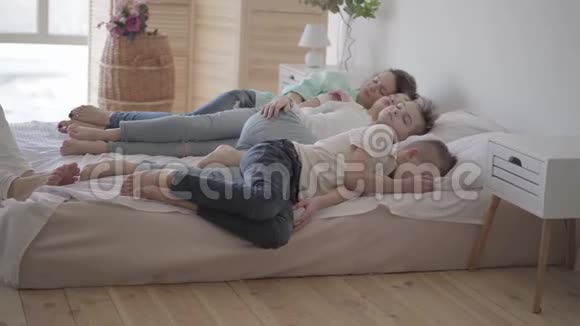 描绘年轻的母亲和她的十几个儿子睡在大床上一个男孩坐在椅子上快乐的爱视频的预览图