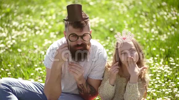 亚里士多德的概念家庭在户外休闲爸爸和女儿坐在草地上绿色的背景视频的预览图