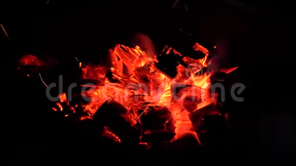炽热的煤块用红蓝色火焰燃烧视频的预览图