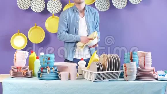 英俊开朗的男人在厨房用毛巾擦盘子视频的预览图