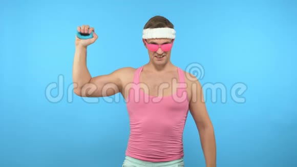 顽皮的帅哥手里拿着一个手动扩张器光明健身运动时尚配件视频的预览图