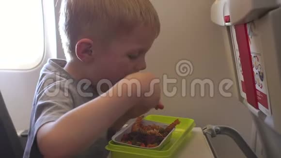 一个小男孩在飞机上吃意大利面和肉视频的预览图