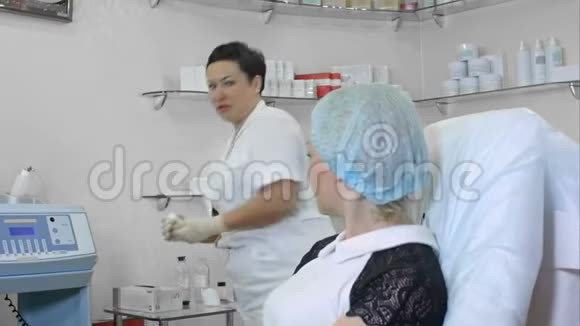 美容师用橡胶手套清洁美容院女性顾客皮肤视频的预览图