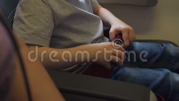 一个小孩的特写在飞机上系安全带视频的预览图