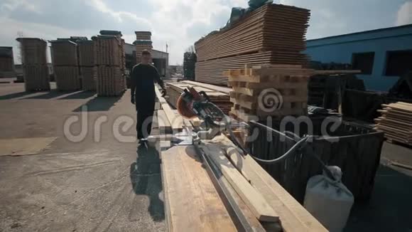 工业年轻木工工人穿着建筑谷歌和使用木材切割机很多托盘视频的预览图