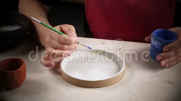 车间里的一位女工正在油漆一块刚准备好的盘子手工制作视频的预览图
