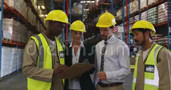 两名经理和两名工人在4k的仓库开会视频的预览图