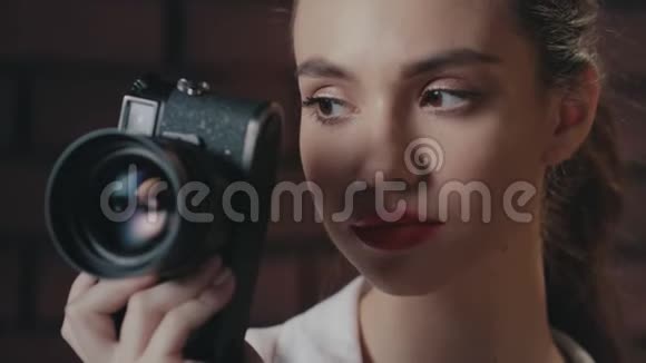 时尚的女摄影师带着复古相机微笑着进入摄影棚视频的预览图