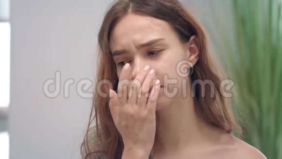 不健康的年轻女孩流鼻涕感冒时打手帕打喷嚏视频的预览图