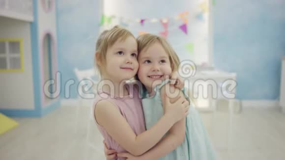 两个快乐的小女孩竖起大拇指互相拥抱站在镜头前视频的预览图