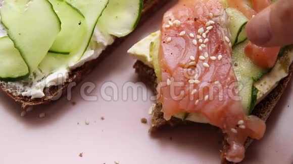带鱼和蔬菜的开放式三明治和粉红色陶瓷盘子视频的预览图