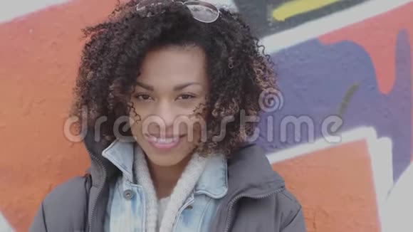 美丽的微笑年轻女子非洲发型户外涂鸦视频的预览图