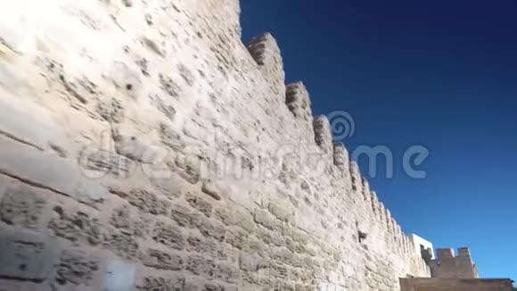 古老的石墙黄色的旧砖沿着墙朝蓝天走视频的预览图