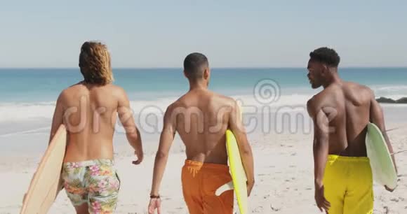 沙滩上带冲浪板的年轻人视频的预览图
