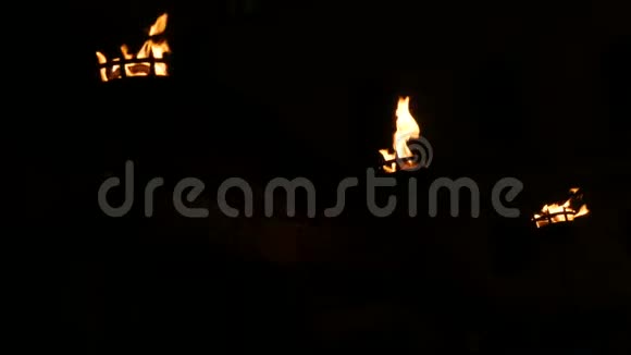 中世纪火炬在黑色背景下黑暗中燃烧的三排火焰视频的预览图