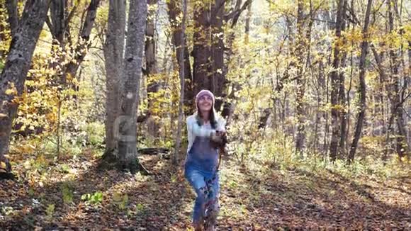 快乐的年轻女子在秋天的森林里玩得很开心视频的预览图