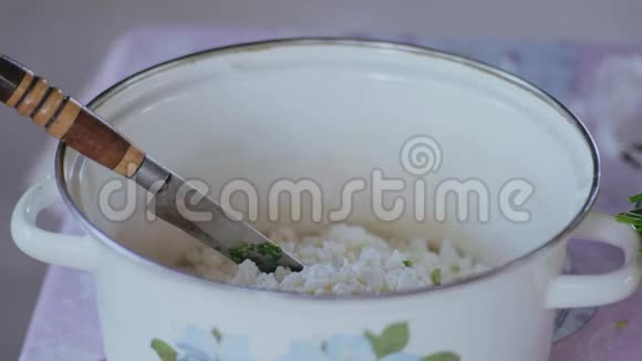 特写镜头中一名男子将欧芹切片倒入盛有沙拉原料的锅中并用刀搅拌视频的预览图