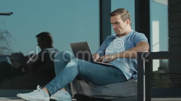 令人心烦的人在笔记本电脑上工作担心的专家坐在户外笔记本上视频的预览图