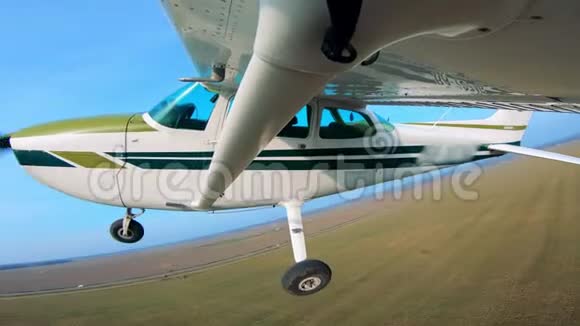 一架小型飞机在地面上空侧视飞行视频的预览图
