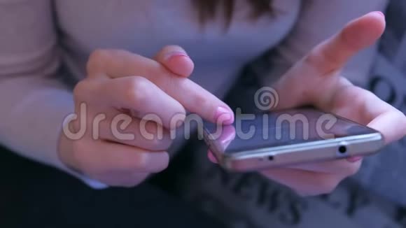 女人用手指在智能手机上翻书双手特写视频的预览图