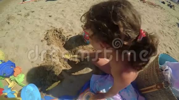 一个坦率的孩子正在海滩上玩水桶和铲子2FDV视频的预览图