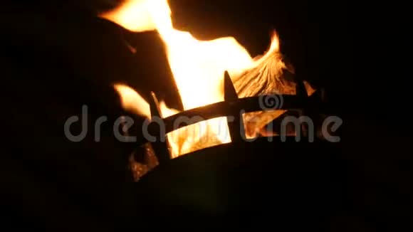 中世纪火炬中的火焰在黑色背景下的黑暗中近距离观看视频的预览图
