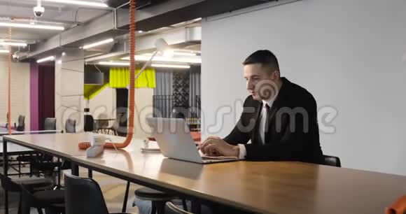 成熟的人在笔记本电脑上工作坐在大公司或同事的办公室视频的预览图