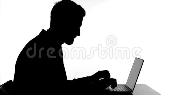 在笔记本电脑上工作的快乐男人庆祝成功的剪影视频的预览图
