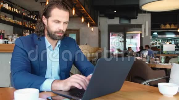 一个年轻的商人用电话坐在咖啡馆的一张桌子旁成功人士日常生活视频的预览图