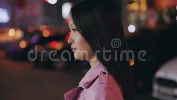 一幅美丽的亚洲女人在夜晚城市转脸看镜头的画像视频的预览图