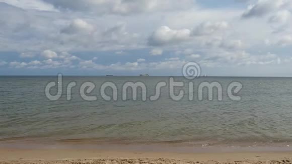 平静的海水撞击海滩巫云和船背景4k视频的预览图