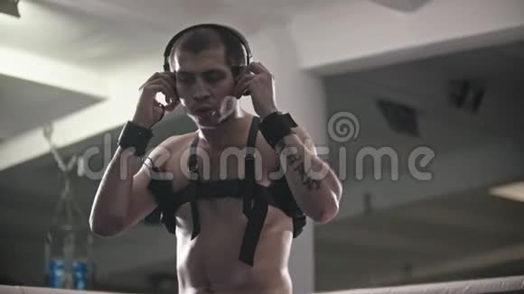 盒子训练一个戴耳机在健身房训练的男人戴约束绷带的影子战斗视频的预览图