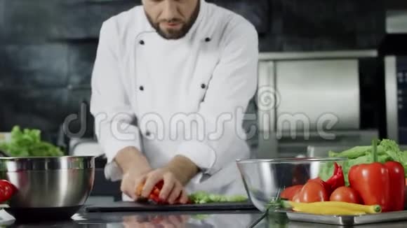 厨师在厨房做沙拉厨师把新鲜蔬菜放进玻璃碗里视频的预览图