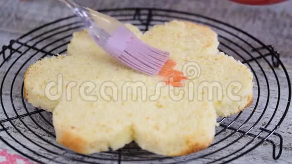 用糖浆浸泡海绵蛋糕层糕点厨师正在做一个粉红色的蛋糕形状像一朵花视频的预览图