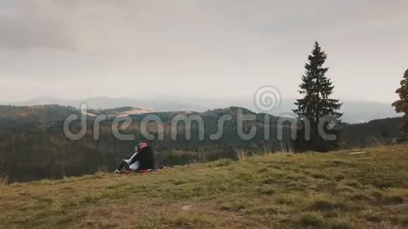 一对夫妇坐在山上看着远处视频的预览图