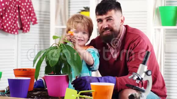 春观念自然与关怀可爱的孩子帮助他的父亲照顾植物种花一个有男孩植物的男人视频的预览图