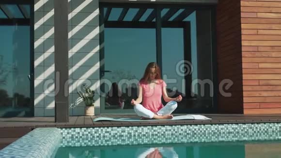 女商人在泳池边打坐放松的女性做瑜伽运动视频的预览图