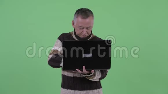 快乐成熟的日本男人一边用手提电脑一边聊天视频的预览图