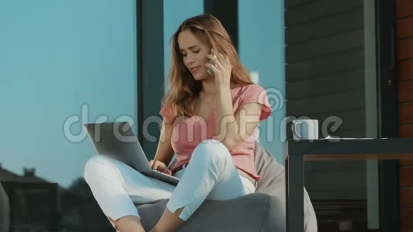忙碌的女人在户外谈论移动电话优雅的女人用手机在笔记本电脑上工作视频的预览图