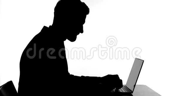 在笔记本电脑上工作的沮丧男人的剪影视频的预览图