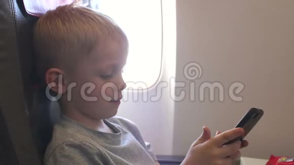 一个小男孩在飞机上玩电子游戏视频的预览图