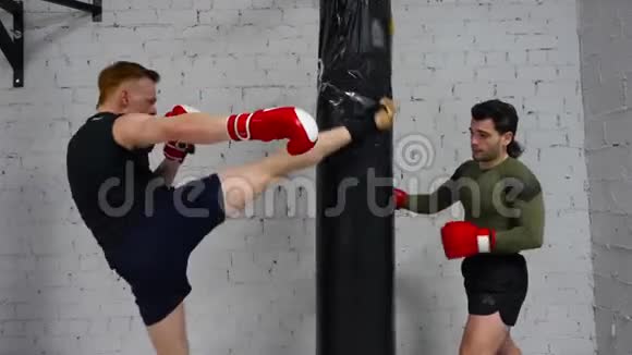 拳击手戴拳击手套的战士在个人训练时在战斗袋上吹气健身教练训练男子拳击视频的预览图