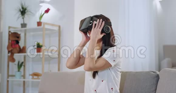 美丽的女人带着美丽的白色微笑用一种新的技术虚拟现实眼镜来探索虚拟视频的预览图