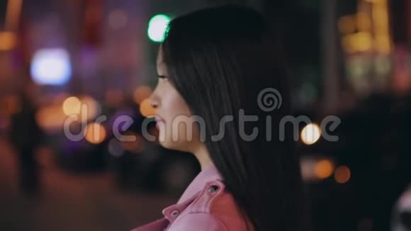 一幅美丽的亚洲女人在夜晚城市转脸看镜头的画像视频的预览图