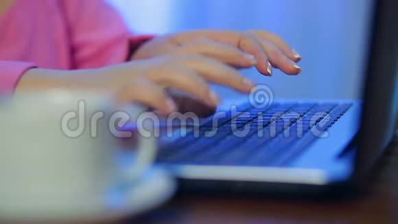 女性的双手在前台的电脑上工作一杯模糊的咖啡视频的预览图