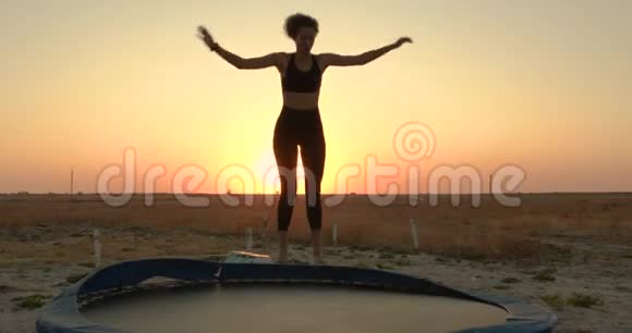 那个女人在日落时跳上蹦床视频的预览图
