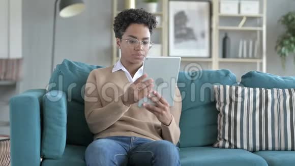 年轻的非洲女孩在桌上做视频聊天视频的预览图