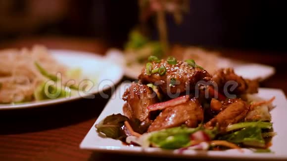 有背景的人在餐馆里把美味的亚洲食物放在盘子里视频的预览图