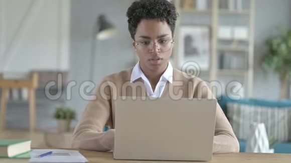 在工作的非洲女孩用笔记本电脑咳嗽视频的预览图
