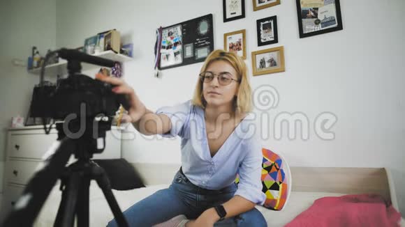 年轻的vloger为博客制作她的视频女孩打开相机开始说话视频的预览图